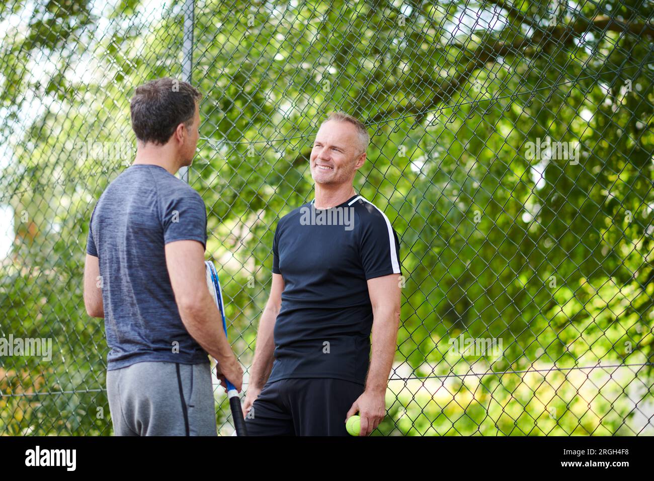 Uomini maturi sul campo da tennis Foto Stock