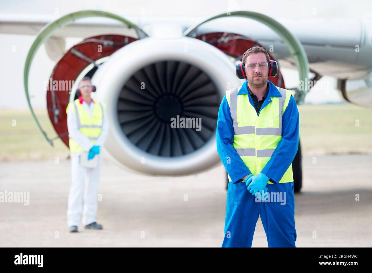 Lavoratori di sesso maschile con il motore dell'aereo Foto Stock