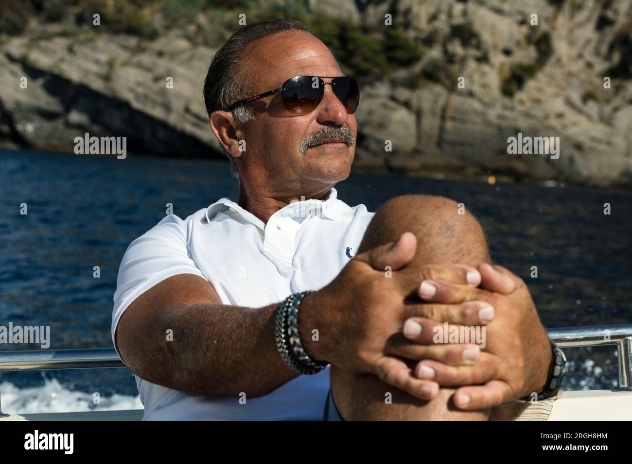 Uomo in pensione che visita la costa di Genova da una barca. Foto Stock