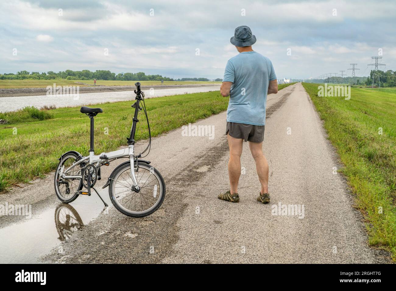 Uomo atletico anziano con una bicicletta pieghevole, pedalando su un sentiero argine lungo il Chain of Rocks Canal vicino a Granite City, Illinois Foto Stock Uomo atletico anziano con una bicicletta pieghevole, pedalando su un sentiero argine lungo il Chain of Rocks Canal vicino a Granite City, Illinois Foto Stock