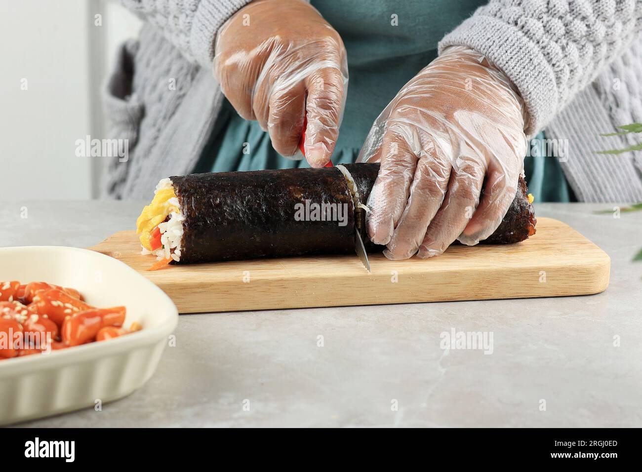 Riso kimbap Korean Roll con coltello. Preparazione di Gimbap, kimbap tagliato, gimbap coreano. Step by Step Making Kimbop Foto Stock