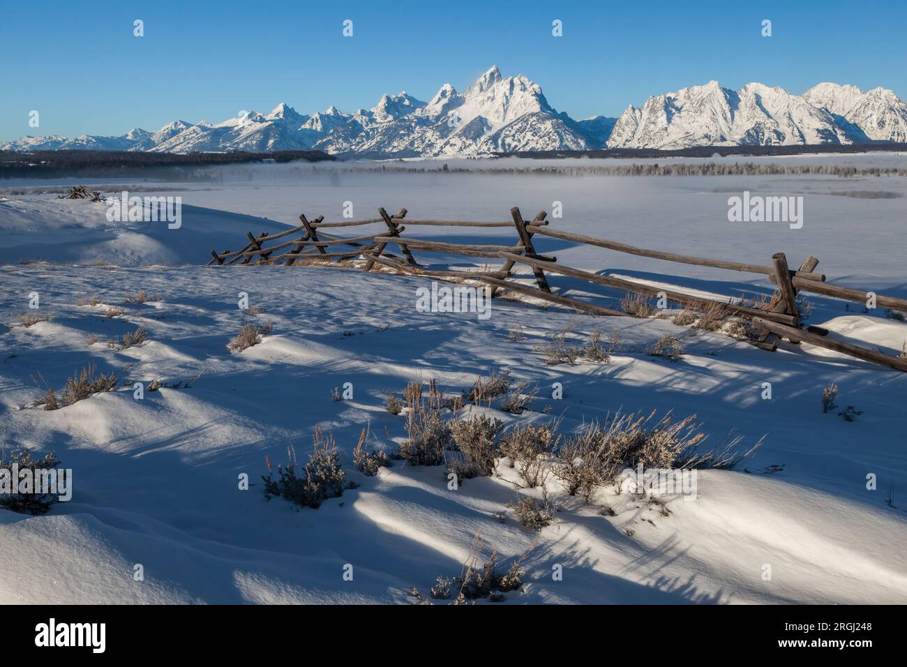 Neve soffiata dal vento e recinzione in inverno, Grand Teton National Park, Wyoming Foto Stock