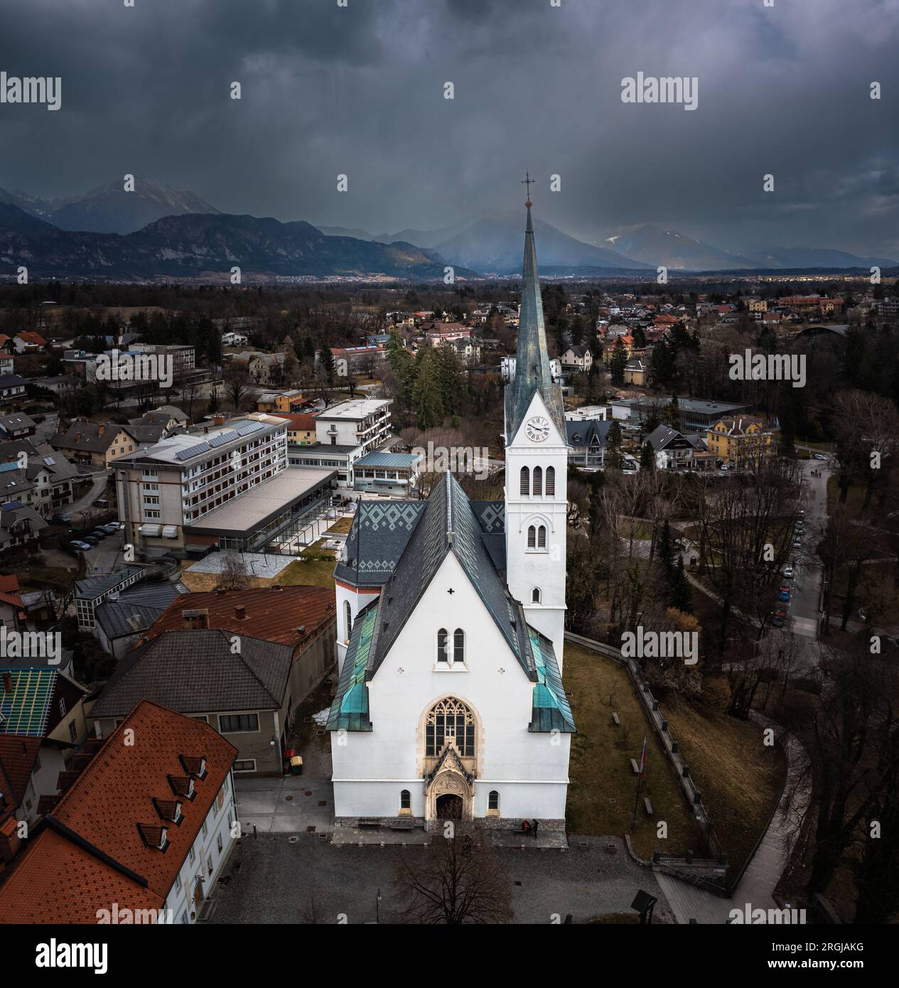 Bled, Slovenia - Vista panoramica aerea di St Chiesa parrocchiale di Martin con Alpi Giulie sullo sfondo in un nuvoloso pomeriggio invernale Foto Stock