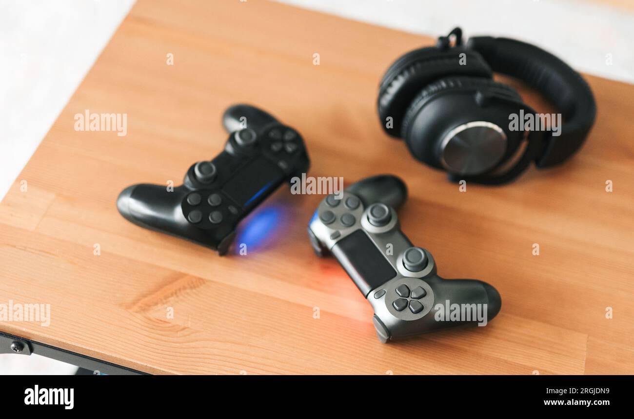 Console per videogiochi. Vista dall'alto un equipaggiamento da gioco sullo sfondo del tavolo. Joystick o gamepad su un tavolo. Foto Stock
