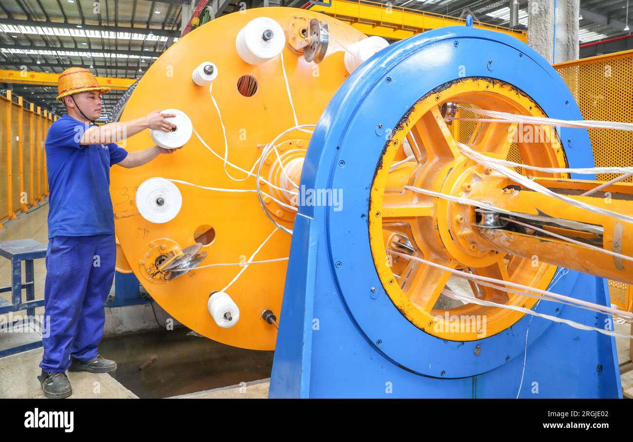 HUZHOU, CINA - 10 AGOSTO 2023 - Un lavoratore produce un lotto di prodotti speciali per cavi in un'officina nella città di Huzhou, provincia di Zhejiang, Cina, 1 agosto Foto Stock
