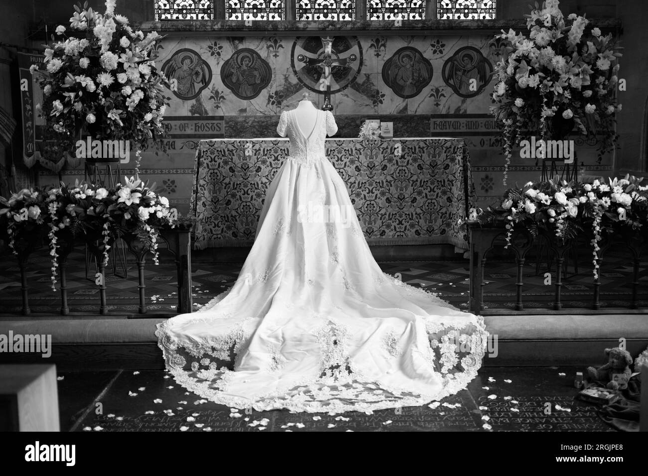 Abito da sposa bianco in mostra davanti all'altare di una chiesa. Foto Stock