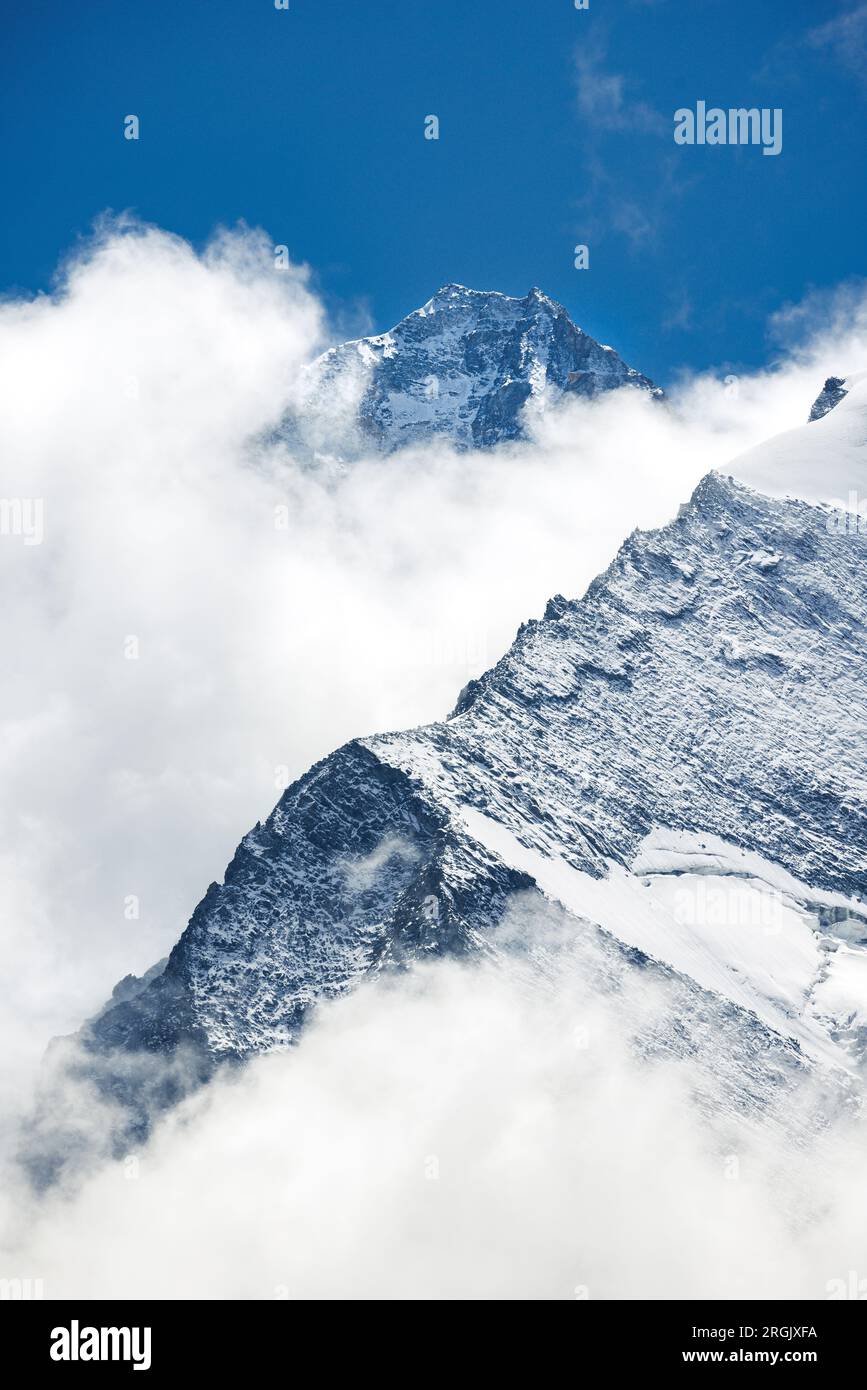 Cime ricoperte di nubi e neve del Grand Cornier e della Dent Blanche sullo sfondo, Vallese Foto Stock