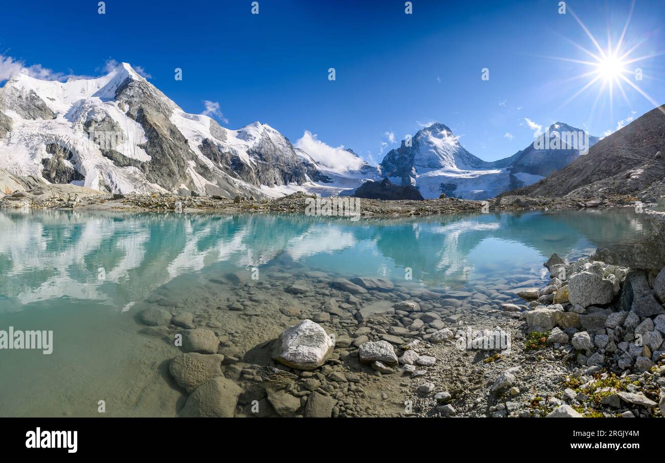 Panorama alpino da Cabane du Mountet con Wellenkuppe, Obergabelhorn, Arbenhorn, Pointe du Zinal, Dent Blanche su un lago ghiacciato, Vallese Foto Stock