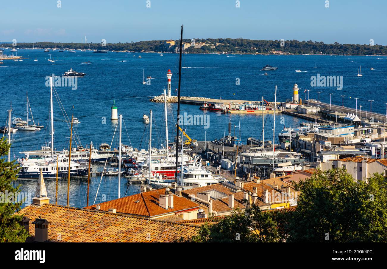 Cannes, Francia - 31 luglio 2022: Centro di Cannes con porto per yacht, faro e isola di Ile Sainte Marguerite sulla Costa Azzurra del Mediterraneo Foto Stock