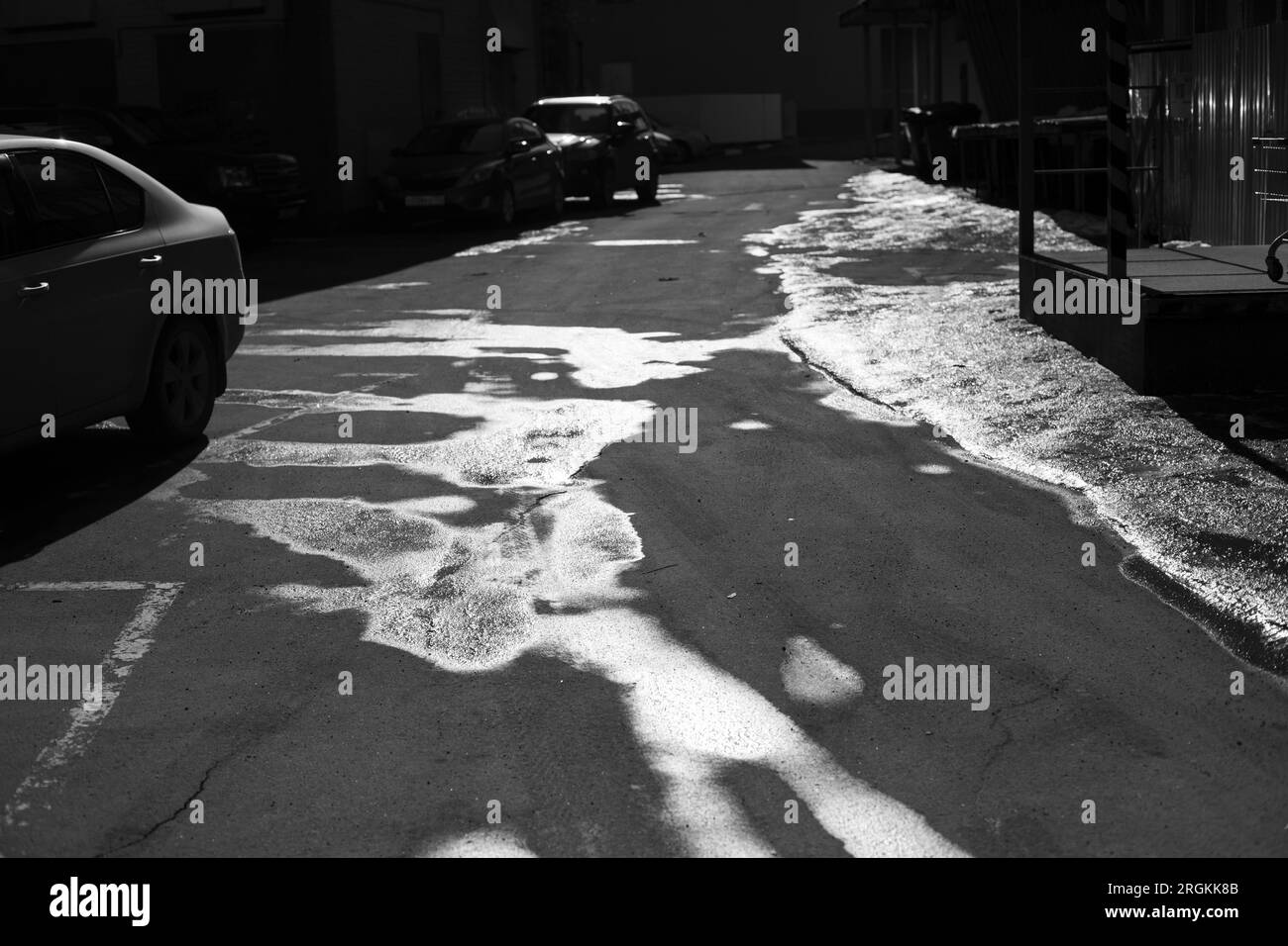 Lois sulla strada. Acqua su asfalto. Strada in città. Foto in bianco e nero della città. Foto Stock