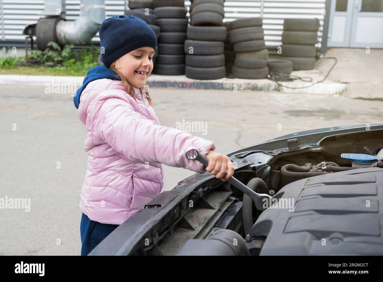 La ragazza felice sta riparando un'auto. Servizio di riparazione Foto Stock