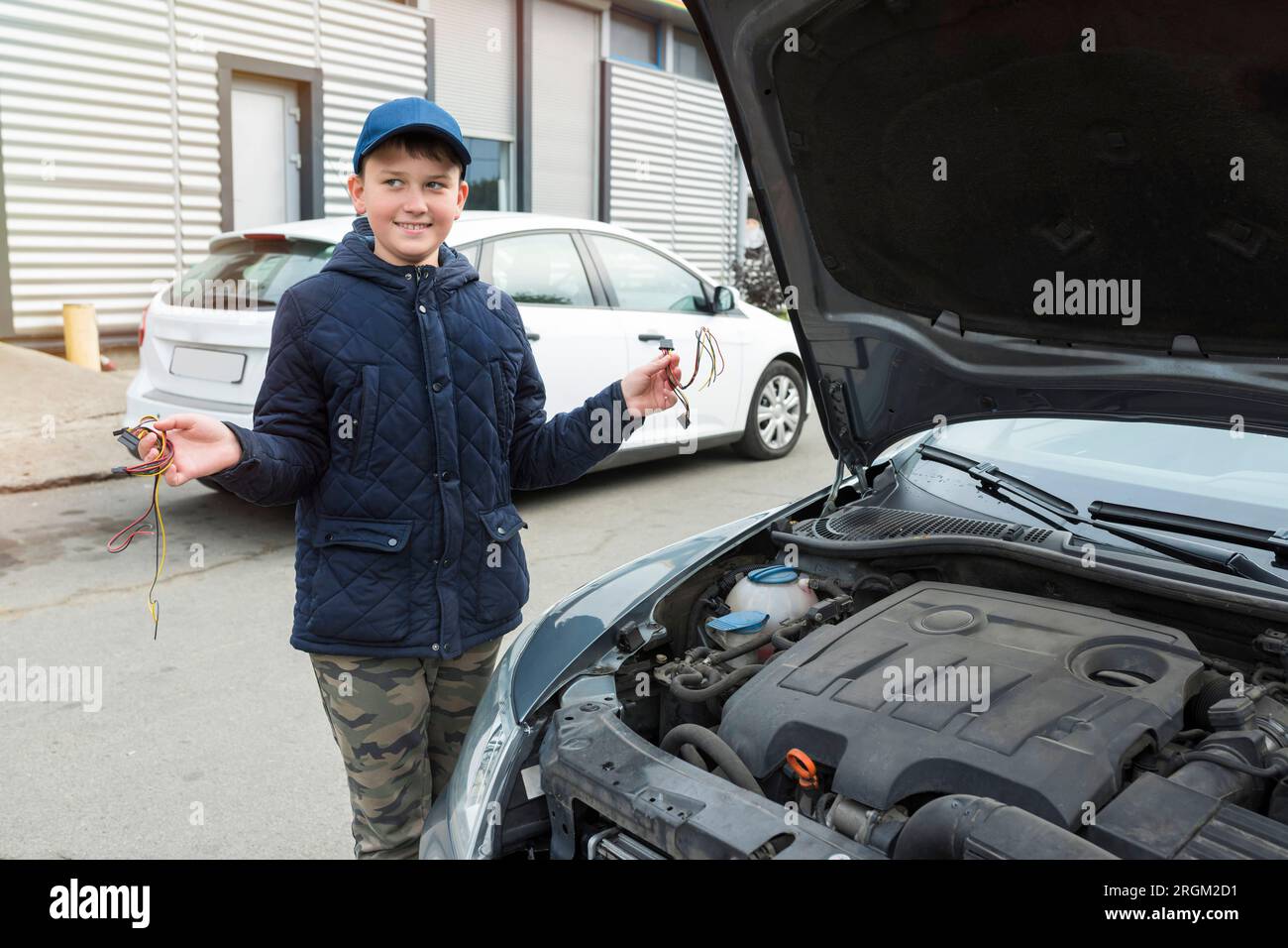 Un ragazzo di 11 anni, in un centro di assistenza auto. Servizio di riparazione, concetto di riparazione auto Foto Stock