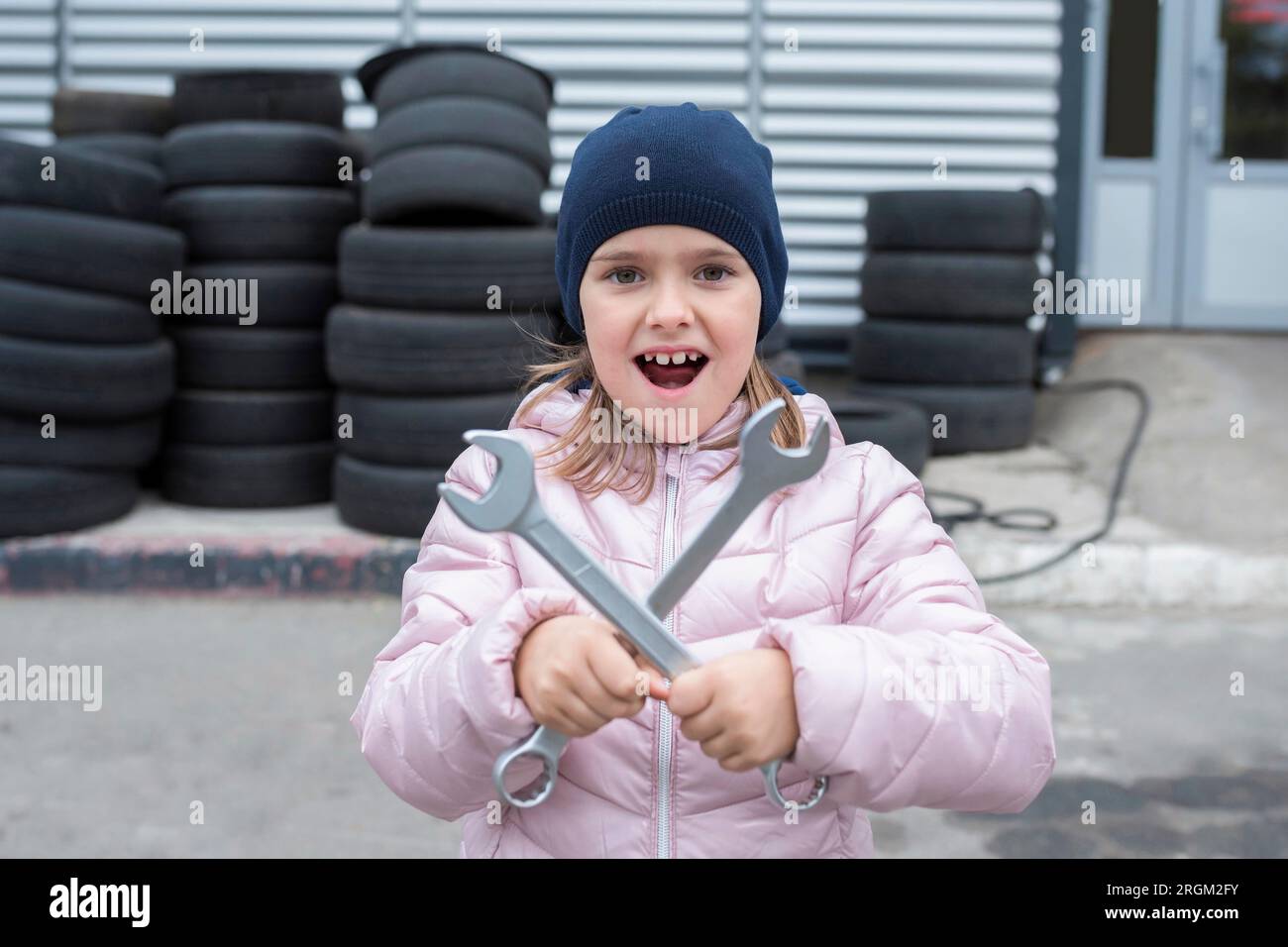Ritratto di un bambino con le chiavi sullo sfondo del garage. Servizio di riparazione Foto Stock