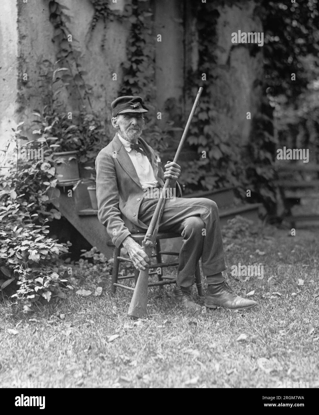 Il sergente Edward S. Duffey di Middleburg, va, seduto su una sedia, con una lunga pistola, CA. 1925 Foto Stock