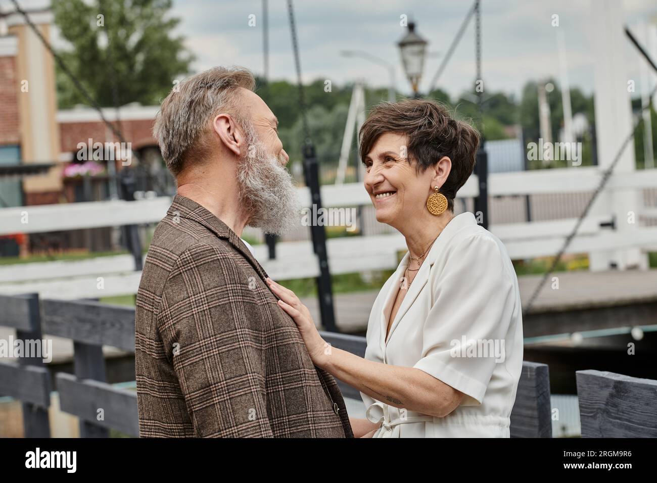 donna anziana felice che abbraccia l'uomo, che si guarda all'aperto, amore e romanticismo, coppia anziana Foto Stock