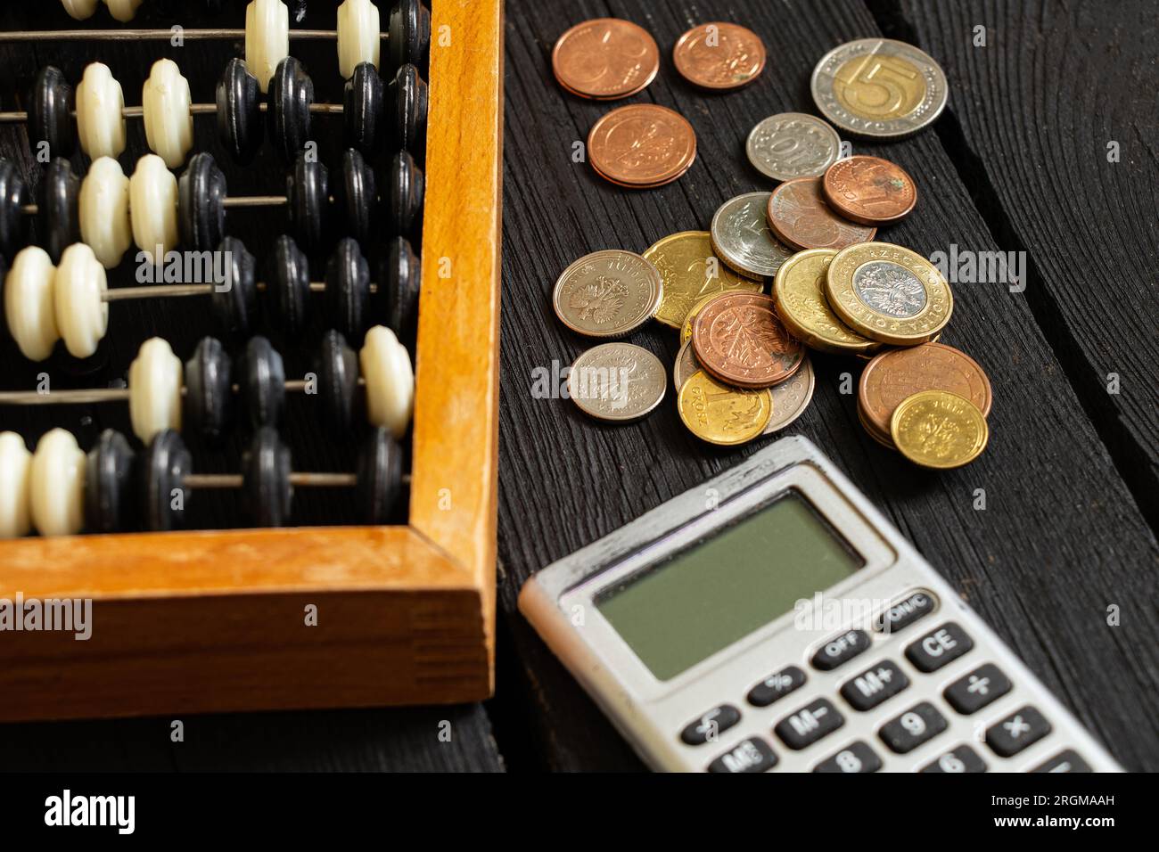 Calcolatrice e nelle vicinanze sono presenti bollette e monete sul tavolo, finanza e affari Foto Stock