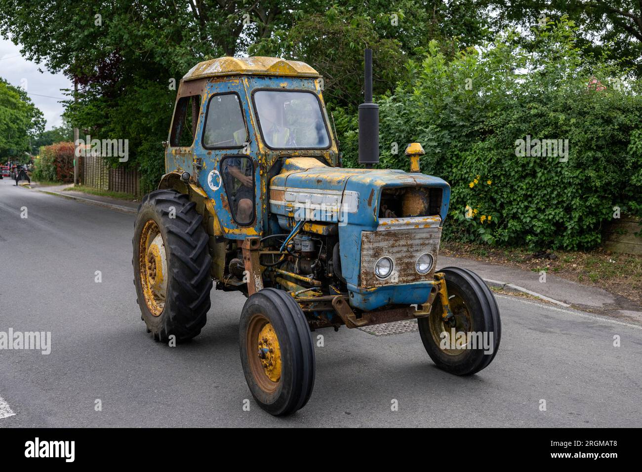 Macchine agricole a Copythorne, New Forest National Park, Hampshire, Inghilterra, U.K. Yellow e Blue Tractor in the New Forest Foto Stock