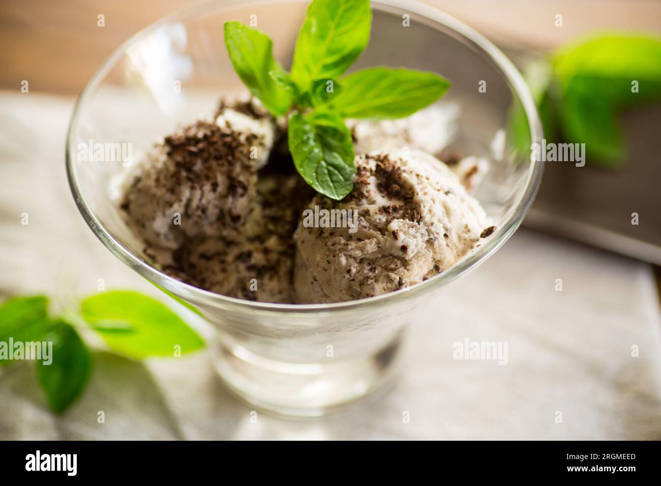 gelato fatto in casa con pezzi di cioccolato fondente grattugiato, in una ciotola su un tavolo di legno. Foto Stock