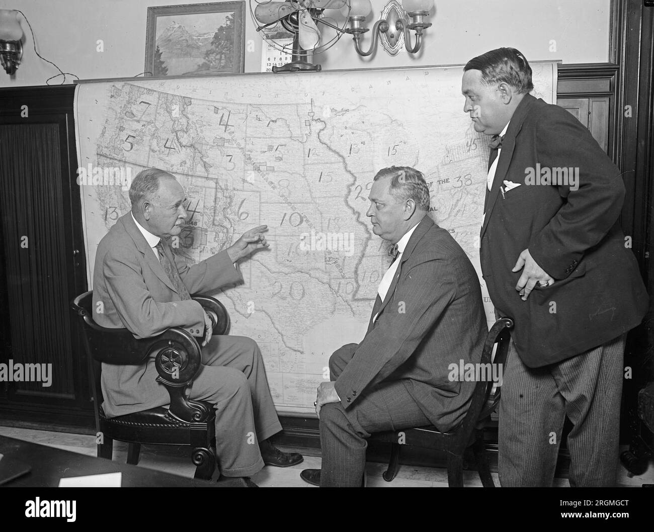 Tre membri del Comitato per la campagna senatoriale democratica discutono di una mappa elettorale CA. 1924 Foto Stock