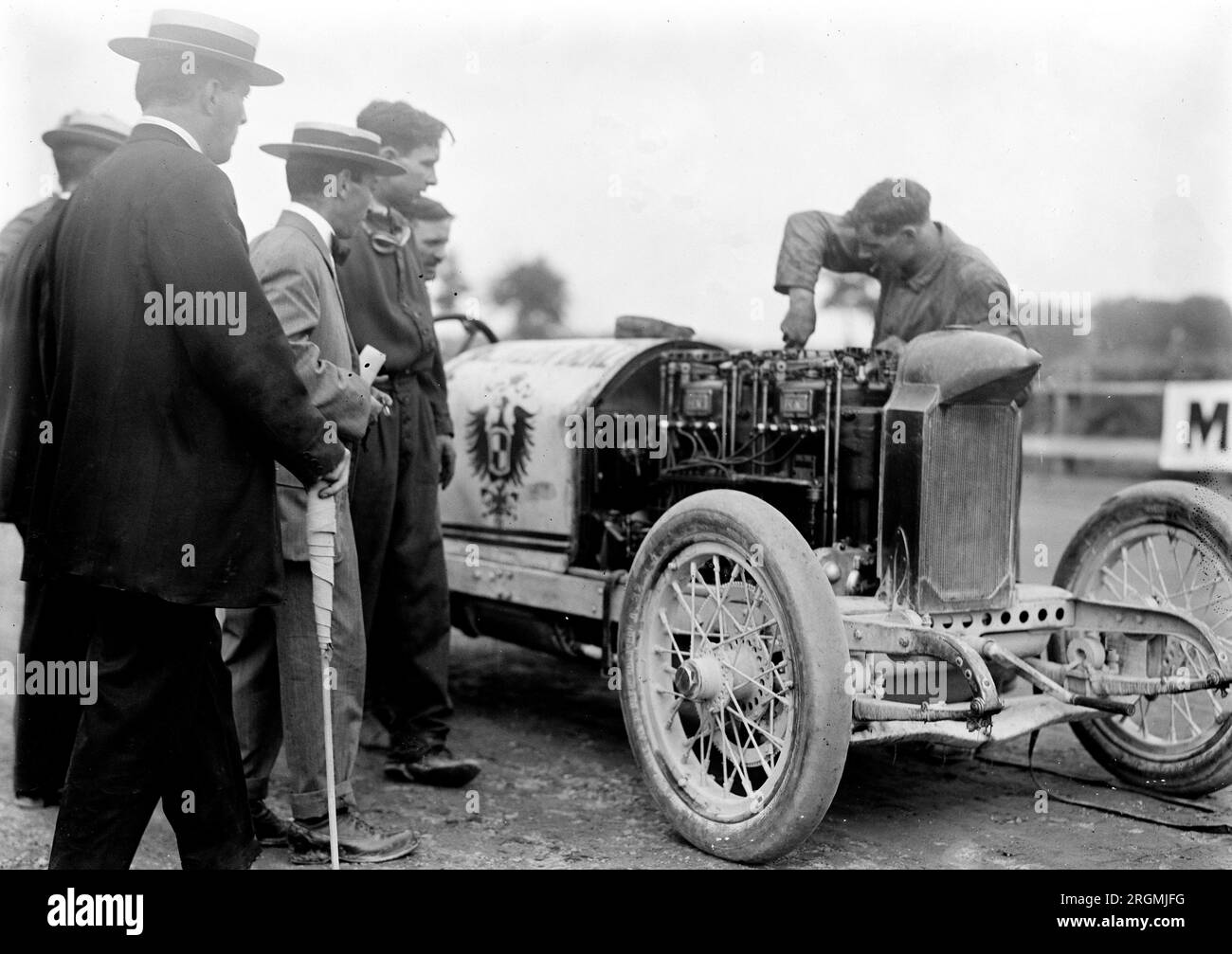 Vintage Auto Racing: Meccanico che lavora su un'auto da corsa sul circuito di Laurel, CA. 1912 Foto Stock