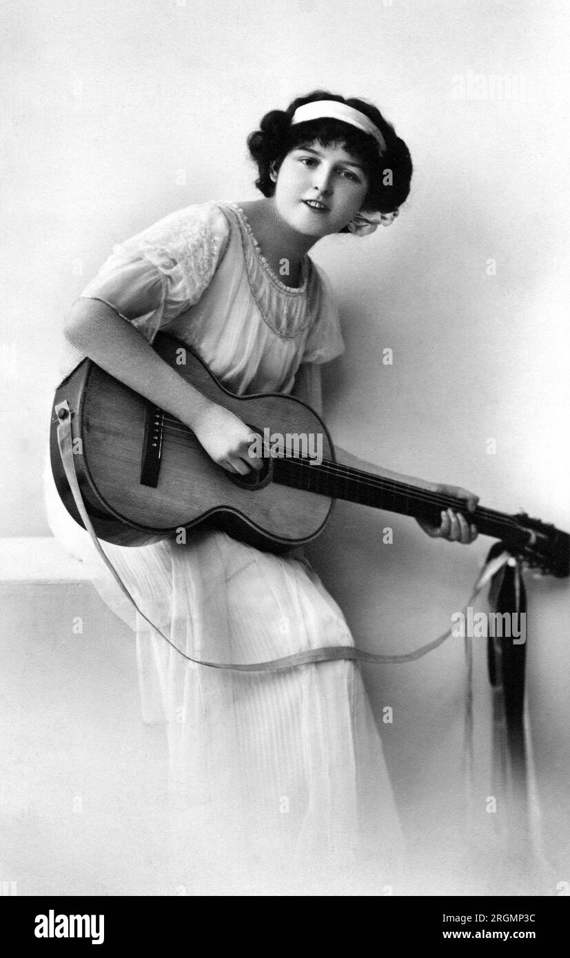 Young Adult Woman with Acoustic Guitar, Postcard, inizio anni '1900 Foto Stock