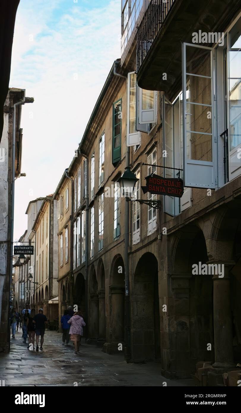 I turisti in una giornata umida di giugno in una stretta strada pedonale del centro storico Santiago de Compostela Galizia Spagna Foto Stock