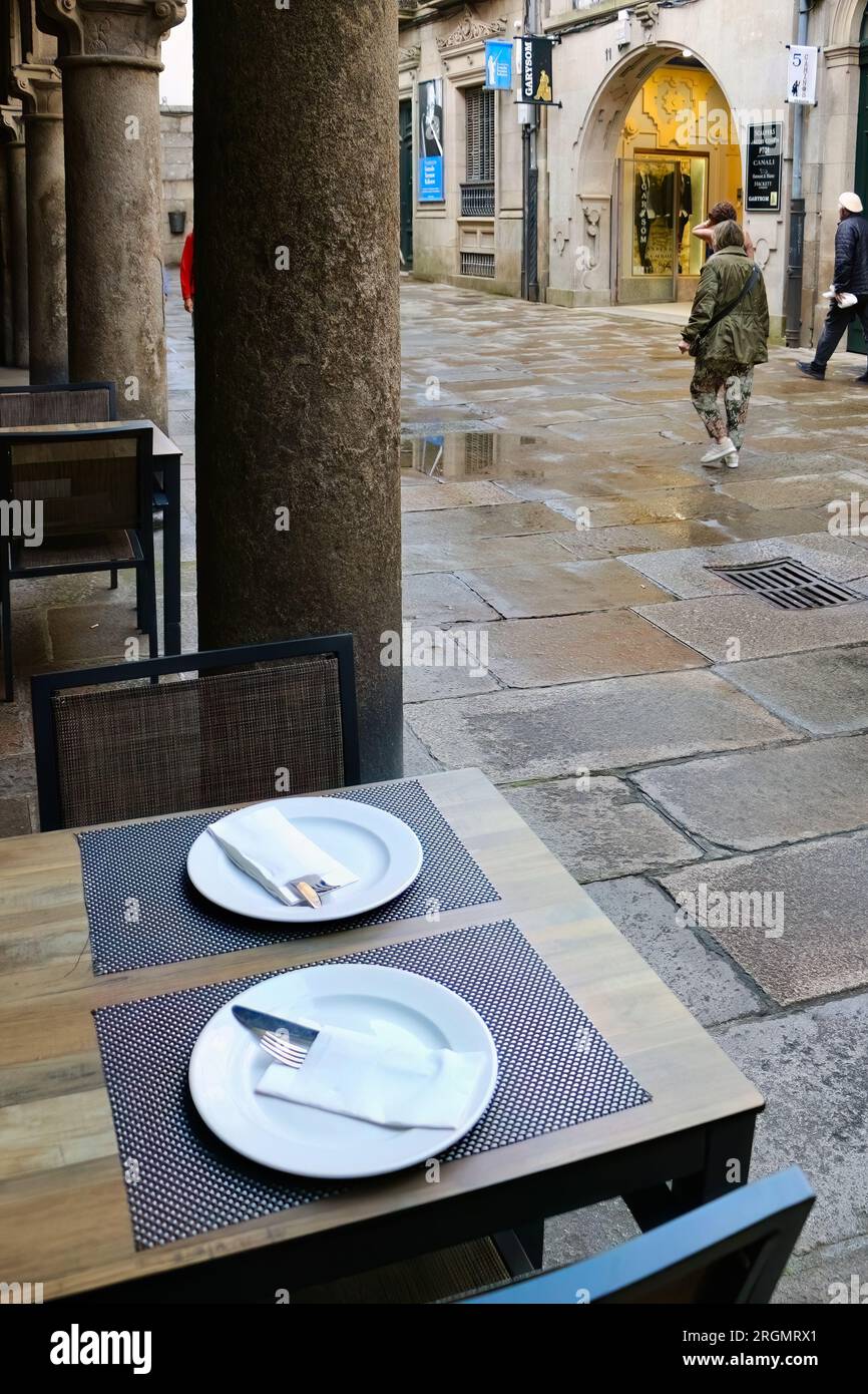 Prepara i tavoli in una piovosa giornata di giugno al Restaurante Central 15 Rúa do Vilar, ingresso Santiago de Compostela, Galizia, Spagna Foto Stock