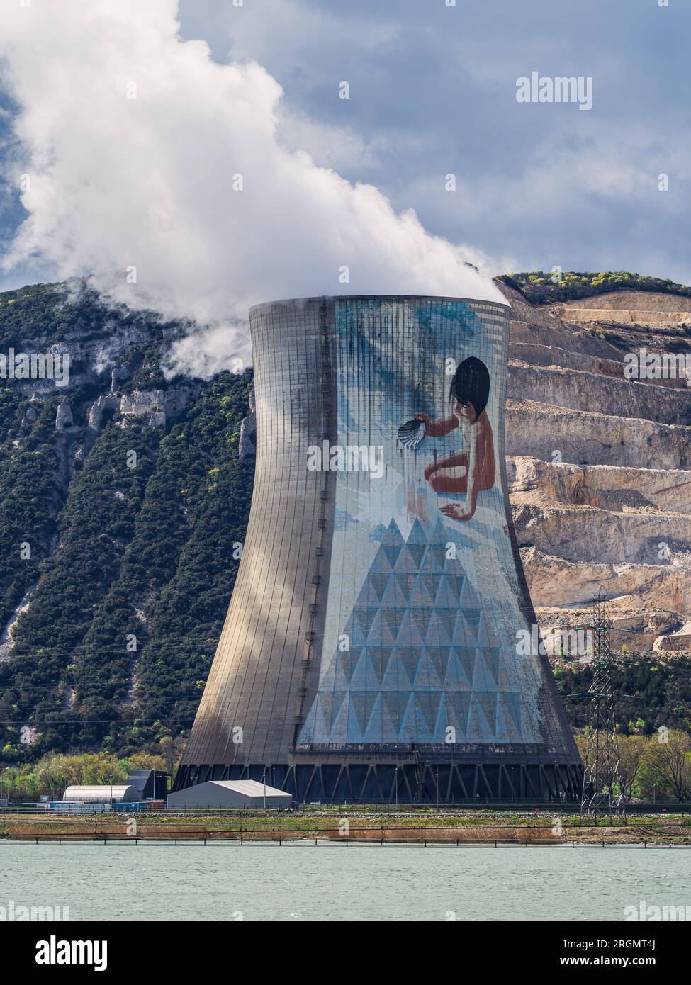 Cruas, Francia - 4 aprile 2023: Vista sul fiume sulla centrale nucleare (CNPE Cruas-Meysse) sullo sfondo di rocce calcaree. Foto Stock
