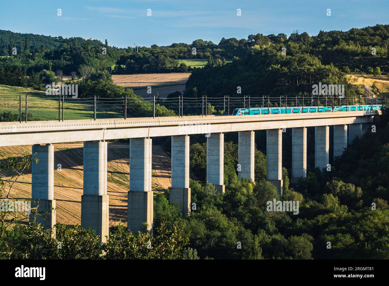 Grane, Francia - 4 agosto 2023: Vista panoramica sul treno passeggeri TGV che attraversa il cavalcavia ferroviario. Vista sulle montagne circostanti in Francia Foto Stock