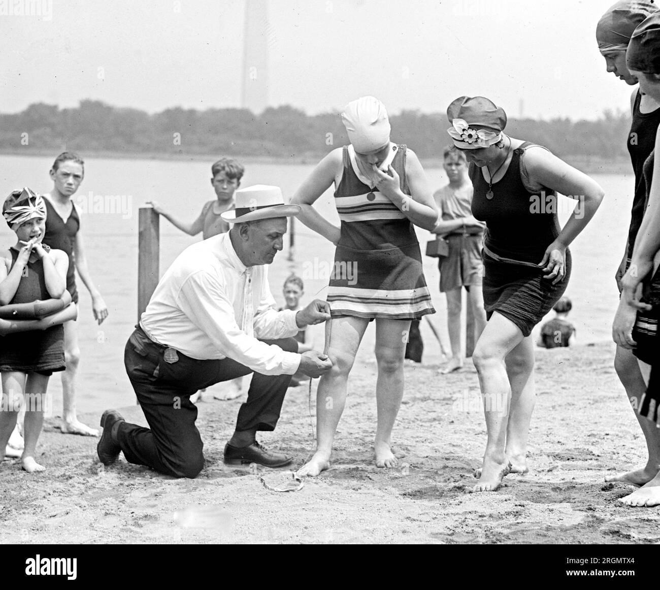 Un uomo che misura i costumi da bagno delle donne ca. 1922 Foto Stock
