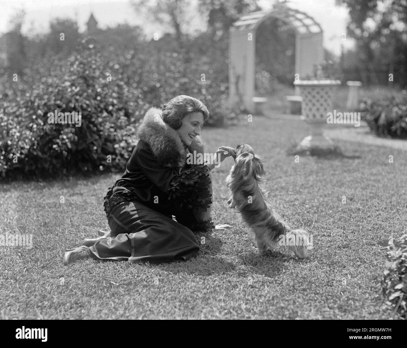 Catherine Radcliffe in un cortile che gioca con un cane CA. 1922 Foto Stock