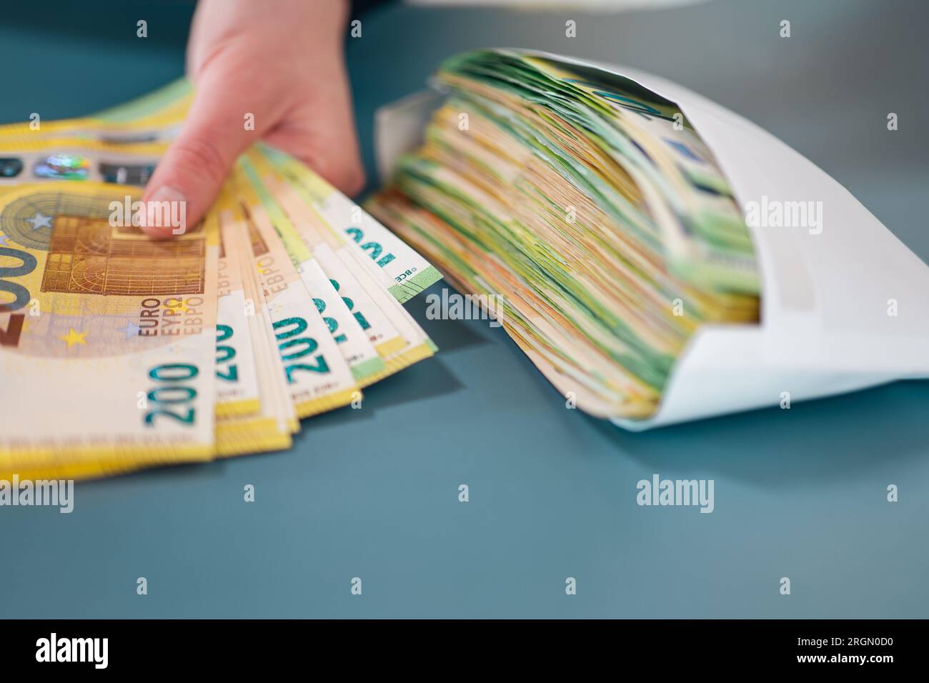 Busta con soldi. Stipendio nella busta. Ricalcolo del denaro. confezione di banconote in euro in una busta su sfondo grigio Expenses and Incomes in EUR Foto Stock