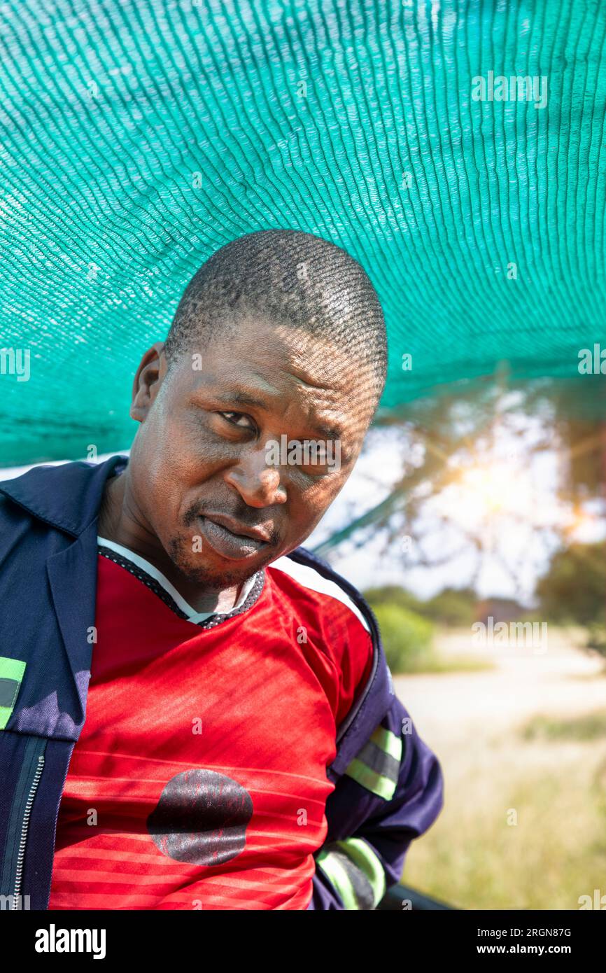 un uomo africano nel villaggio in piedi nel capanno sotto la rete Foto Stock