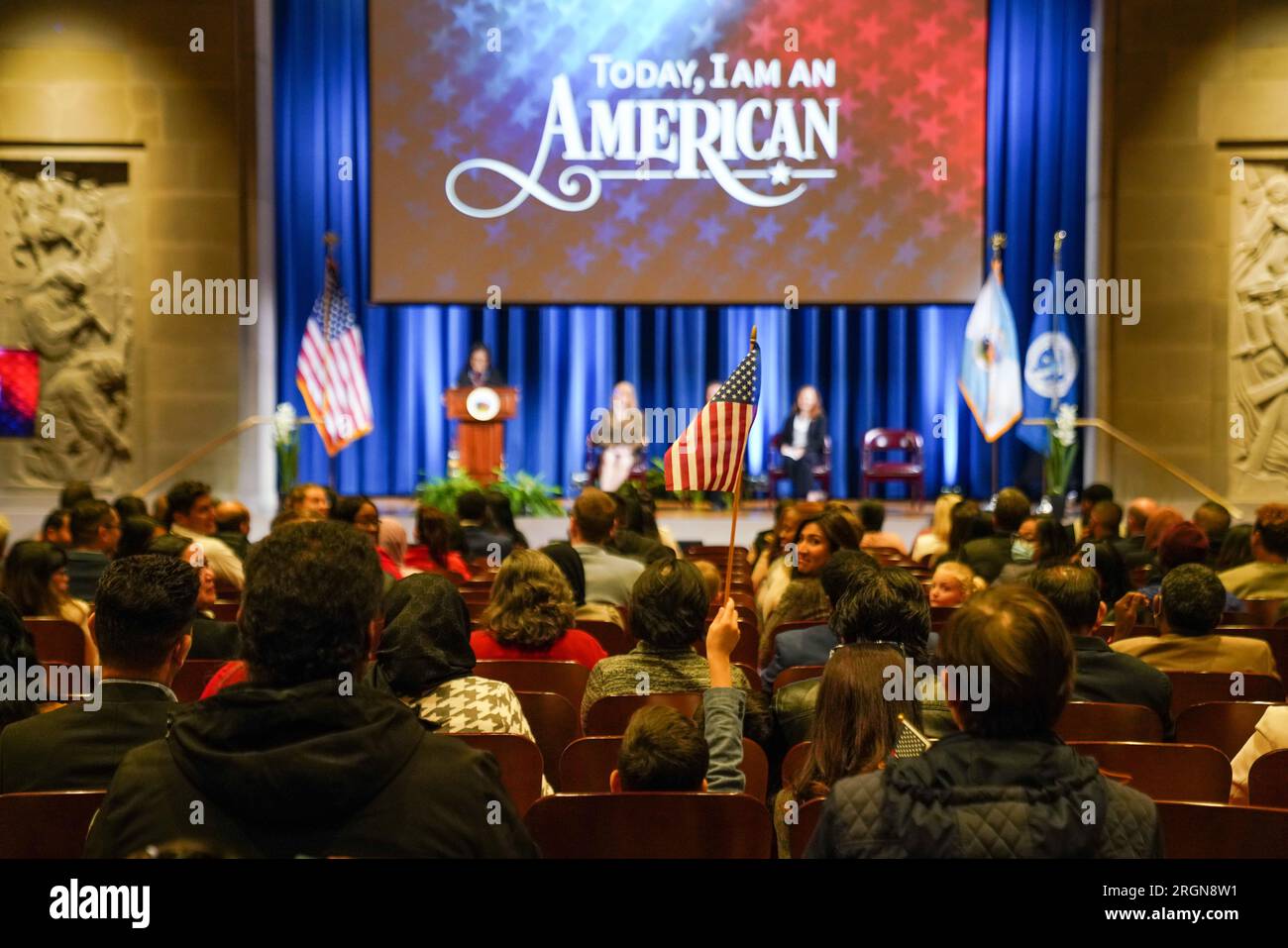 Reportage: Segretario Deb Haaland alla cerimonia di Naturalizzazione presso lo Stuart Lee Udall Building a Washington, D.C. (novembre 2022). Un ragazzo nella folla batte una piccola bandiera americana. Foto Stock