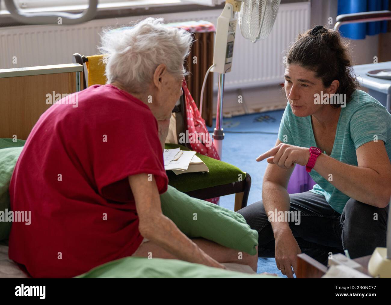 Berlino, Germania. 31 luglio 2023. L'infermiera Ramona Rössner parla con la sua paziente, 97 anni, Brigitte Richter, che ha bisogno di cure, durante una visita a casa. Crediti: Monika Skolimowska/dpa/Alamy Live News Foto Stock
