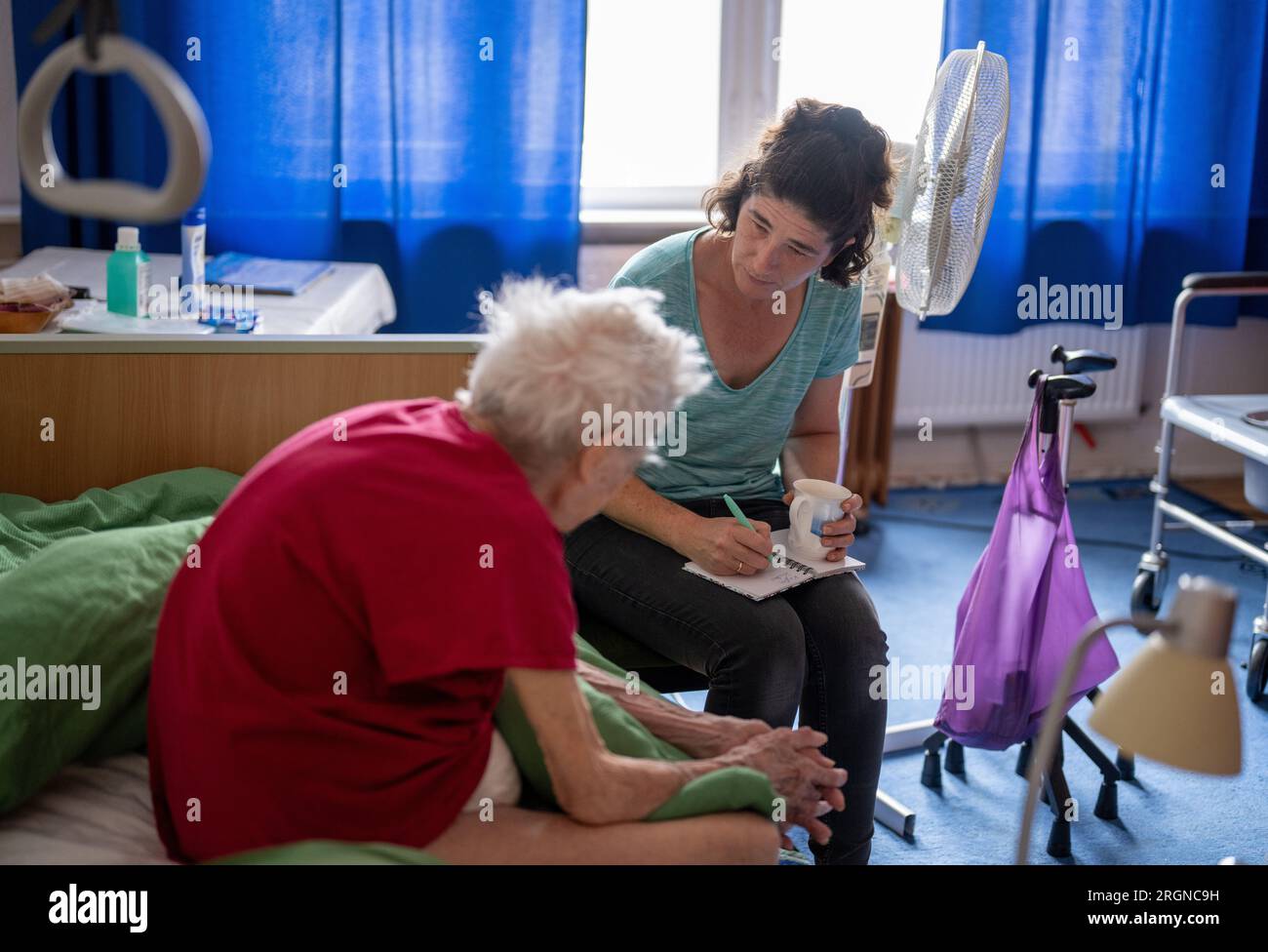 Berlino, Germania. 31 luglio 2023. L'infermiera Ramona Rössner ascolta la paziente Brigitte Richter, 97 anni, che ha bisogno di cure, durante una visita a casa. Crediti: Monika Skolimowska/dpa/Alamy Live News Foto Stock