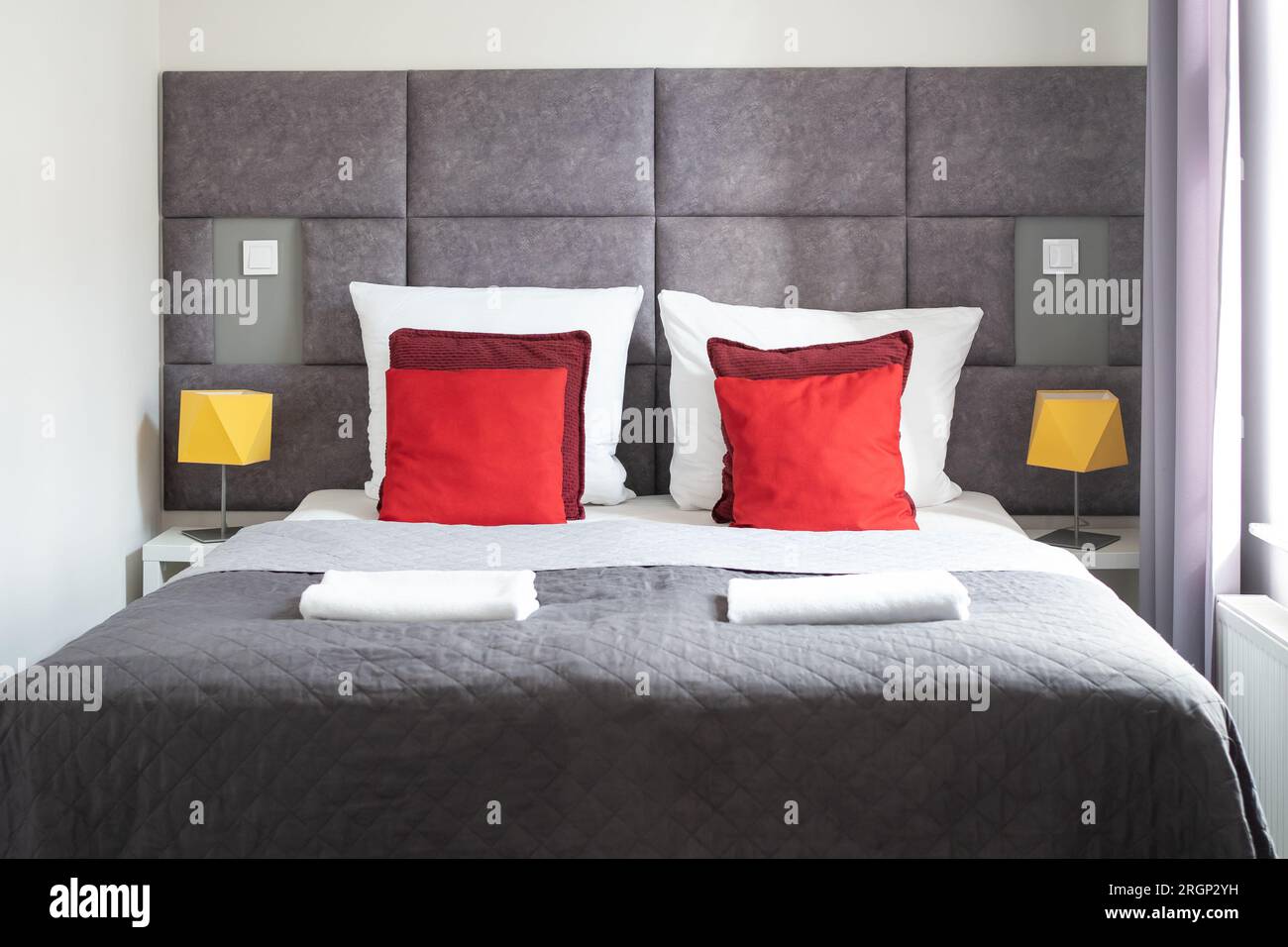 letto matrimoniale con testiera, cuscini e copertura grigia in camera  d'hotel Foto stock - Alamy