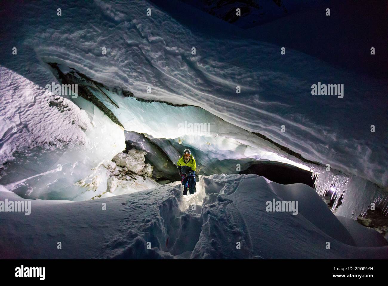 Vista dall'alto o esploratore che entra nella grotta glaciale di notte Foto Stock