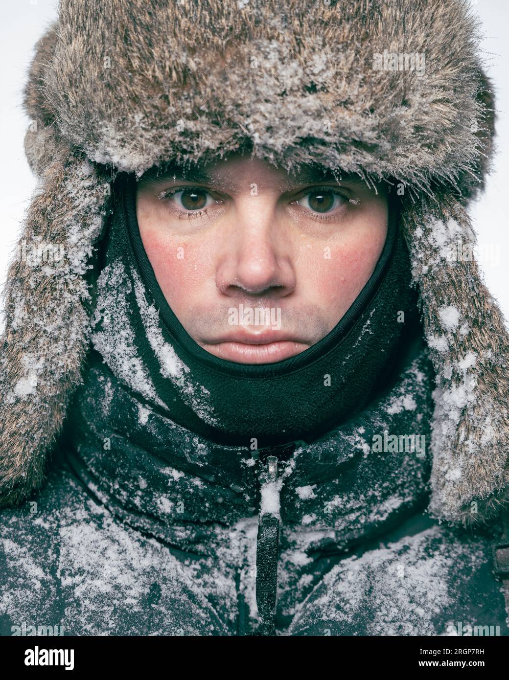 Ritratto di un uomo con un cappello di pelliccia congelato con ghiaccio e neve Foto Stock