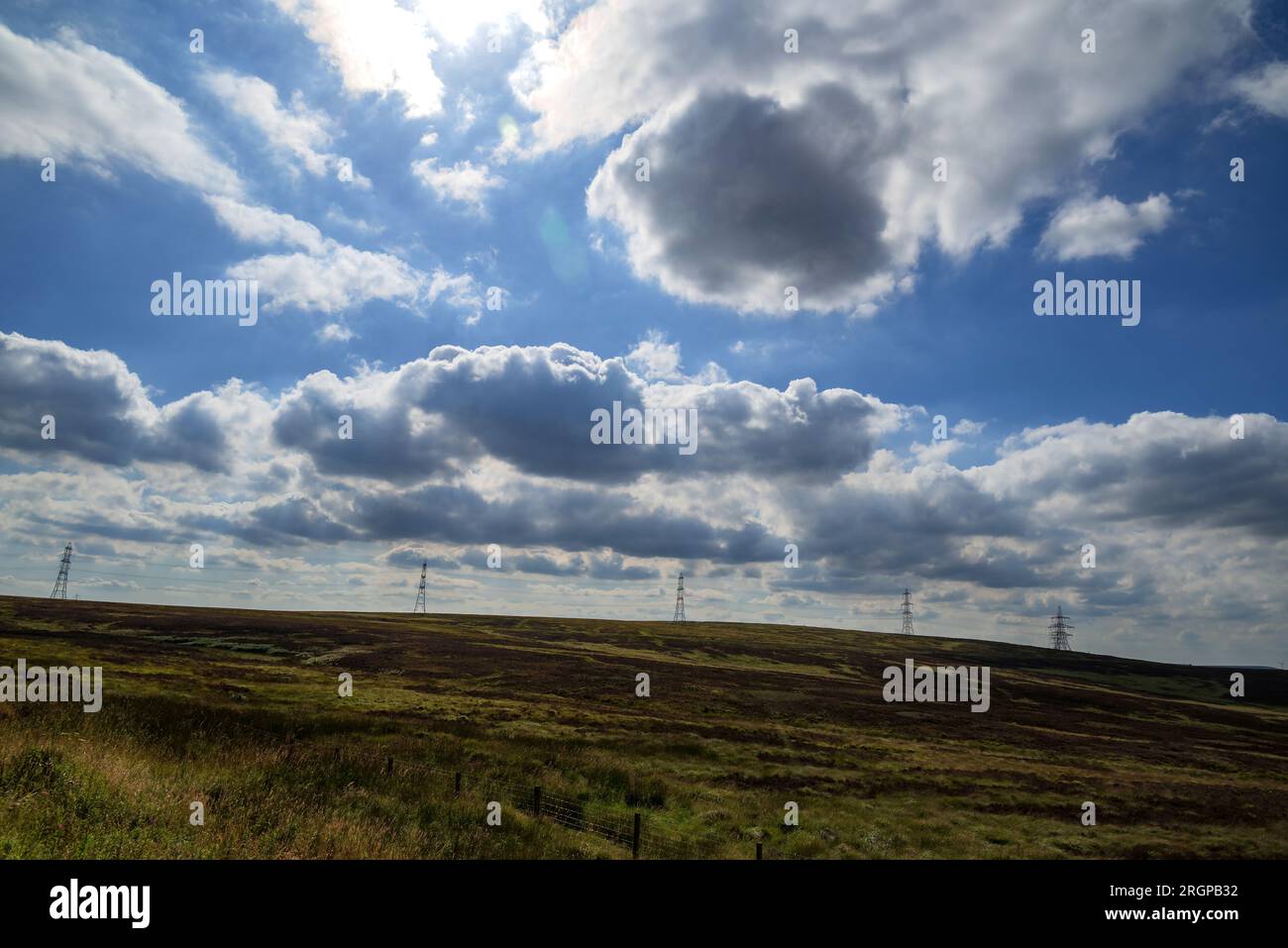 Piloni elettrici che attraversano la brughiera solitaria nel West Yorkshire. Foto Stock