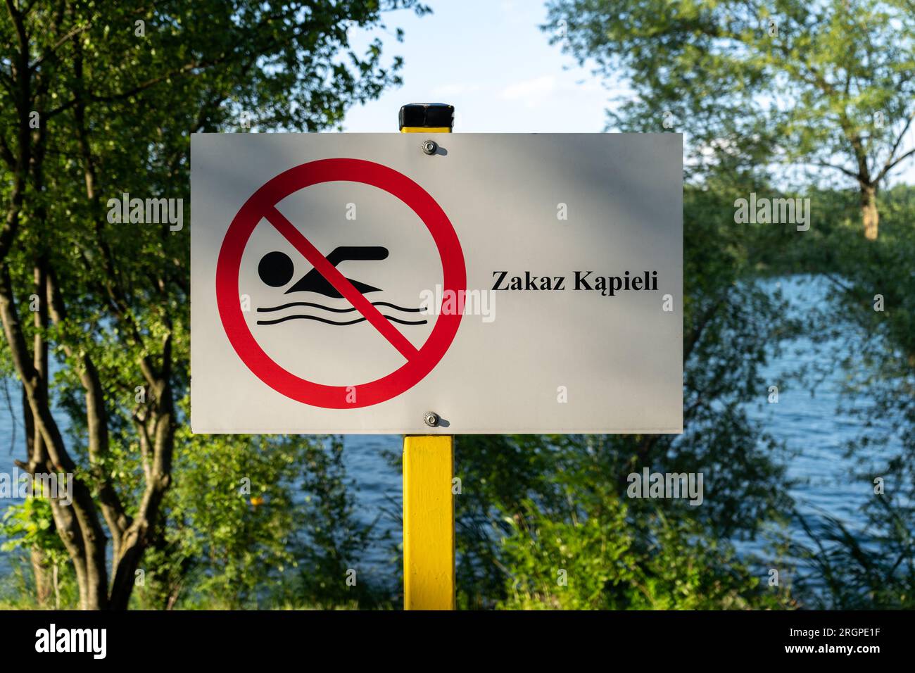 Cartello "No Swimming". Nessuna segnaletica per l'area di nuoto, montata sulla riva del lago in Polonia. Il testo in polacco Zakaz kąpieli significa nuoto proibito. Foto Stock