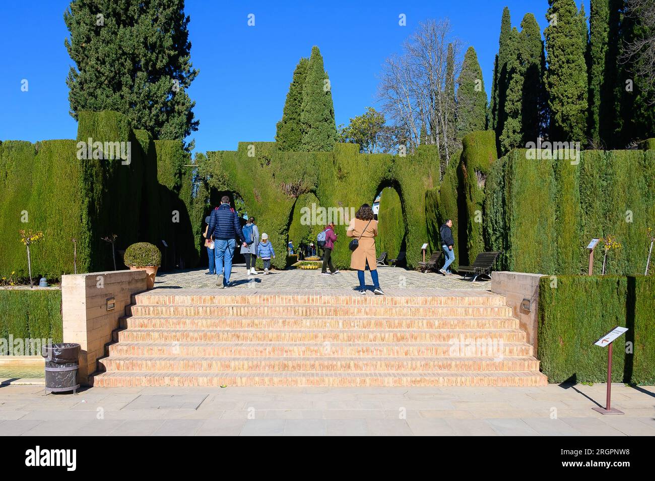 L'Alhambra, la Spagna, turisti o persone passeggiano nei giardini scolpiti del monumento internazionale. L'Alhambra è un palazzo medievale e un complesso di fortezza Foto Stock