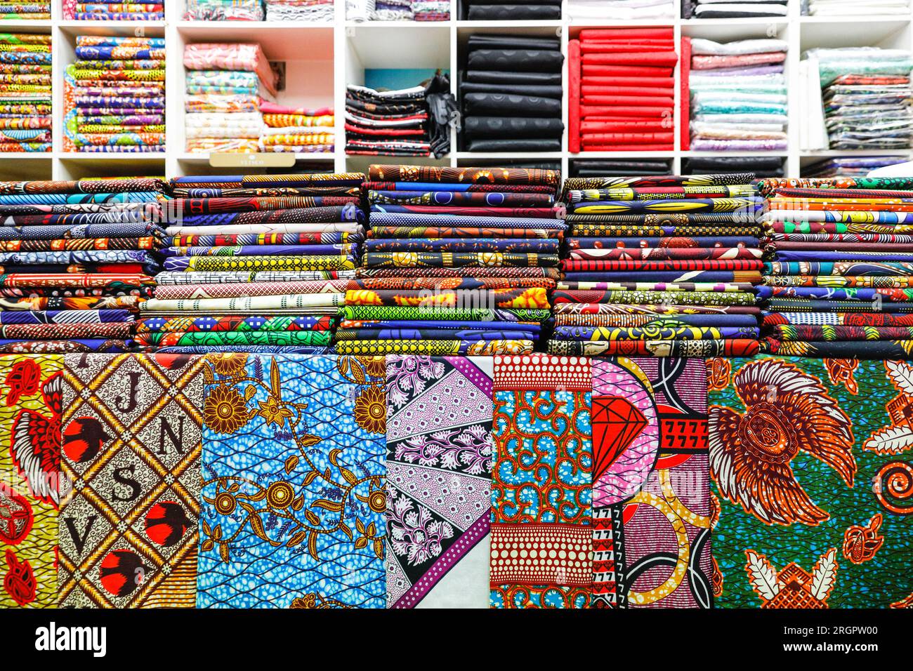 Tessuti e modelli africani e afro-caraibici venduti in un negozio a Brixton Village, popolare sala giochi al coperto, Brixton, South London, Inghilterra, Regno Unito Foto Stock