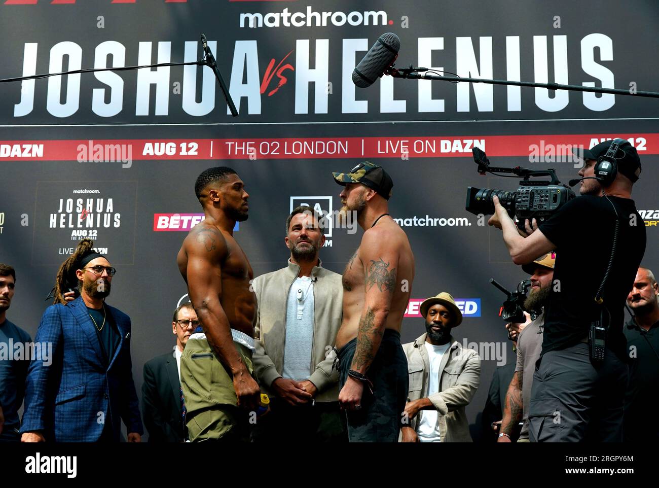 Il presidente e promotore della Matchroom Sport Eddie Hearn (centro) si trova tra Anthony Joshua (sinistra) e Robert Helenius mentre si affrontano durante il peso pubblico al Westfield London. Data immagine: Venerdì 11 agosto 2023. Foto Stock