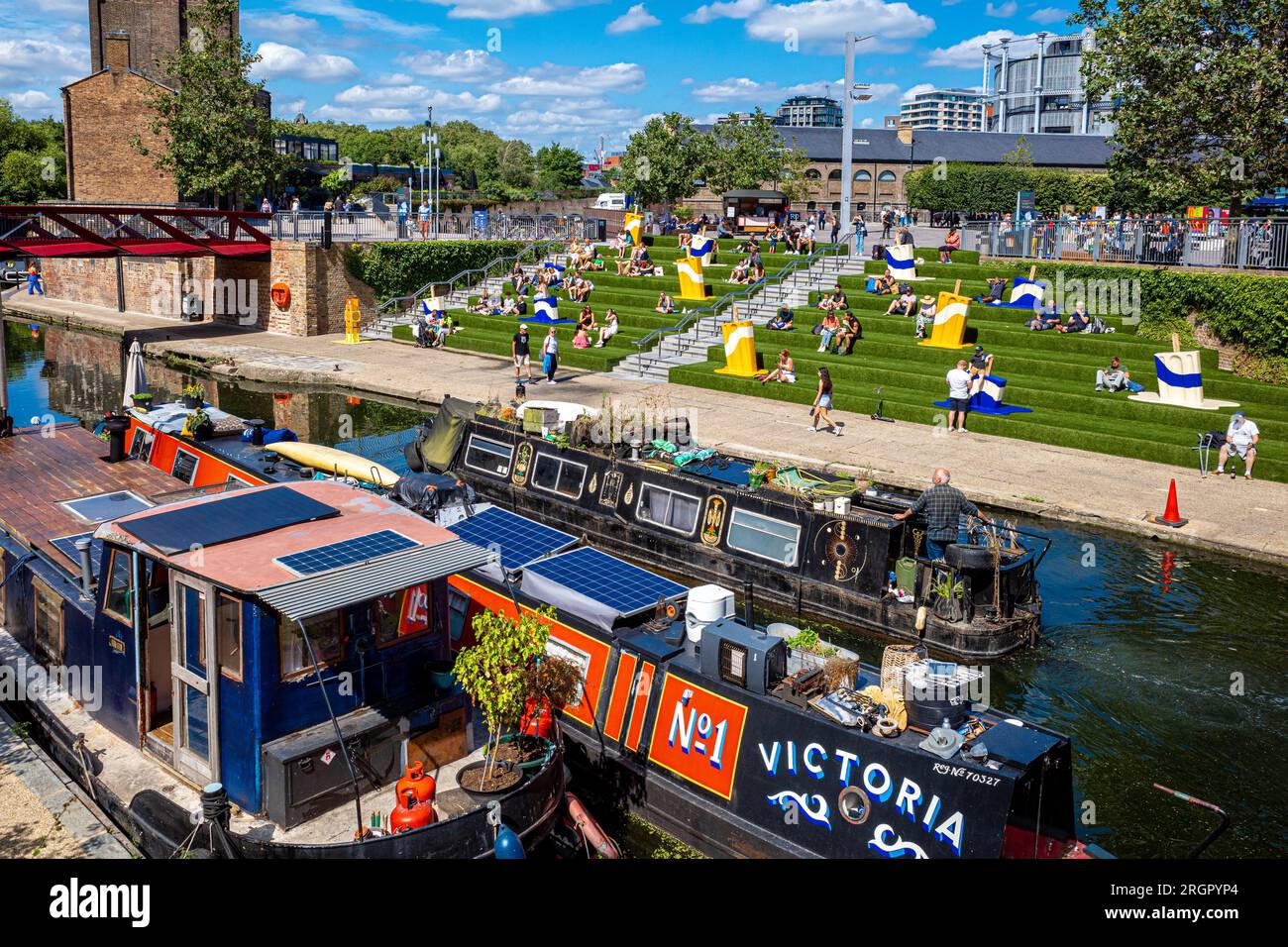 Granary Square Kings Cross Londra - Coal Drops Yard - posti a sedere estivi sul lato del Regents Canal. London Kings Cross Development. Foto Stock