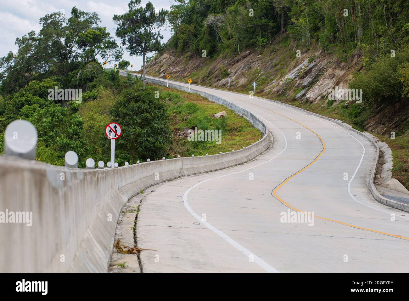 Strade curve, pendii e segnali stradali nella zona di divieto di sorpasso. Foto Stock