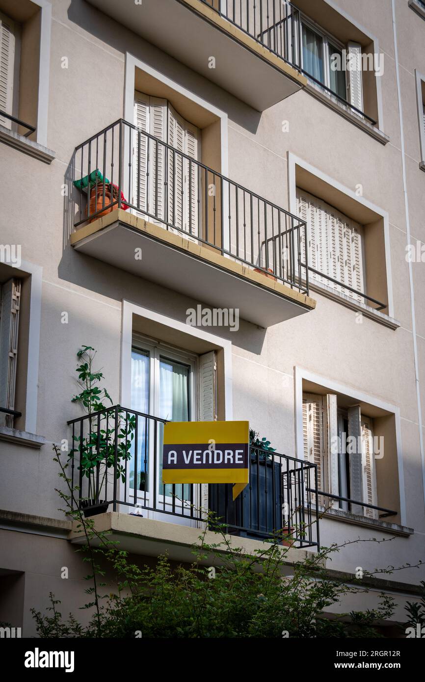 "Un vendre" scritto in francese su un cartello giallo fissato all'esterno di un appartamento in un edificio residenziale. Concetto di mercato immobiliare in Francia Foto Stock