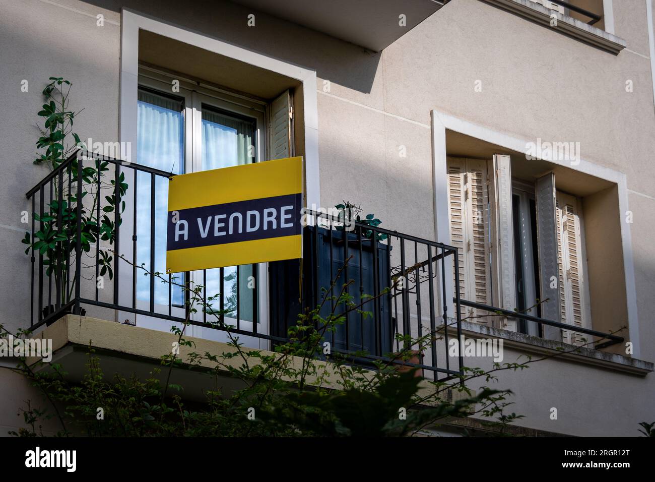 "Un vendre" scritto in francese su un cartello giallo fissato all'esterno di un appartamento in un edificio residenziale. Concetto di mercato immobiliare in Francia Foto Stock