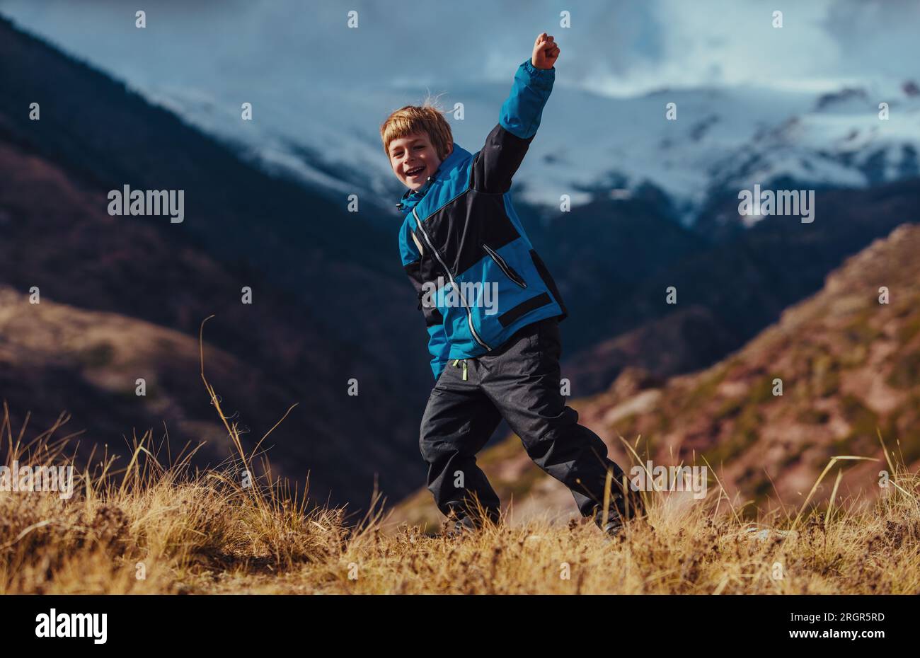 Felice ragazzo di successo sulle montagne in autunno Foto Stock