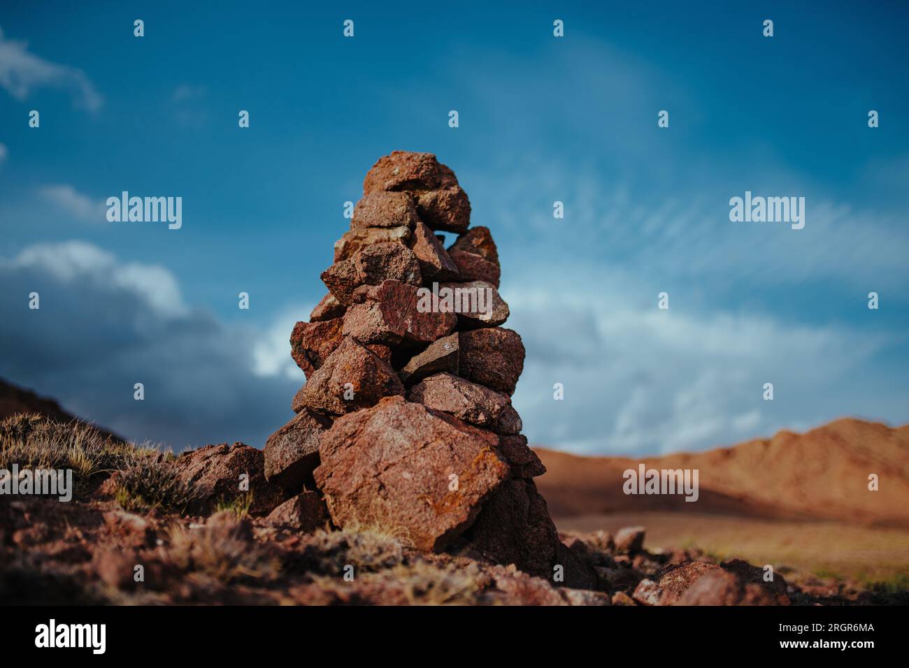 Torre in pietra fatta a mano in montagne sullo sfondo del cielo Foto Stock